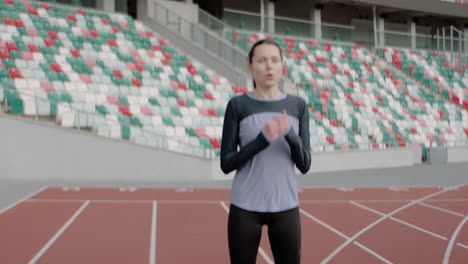 Porträt-Einer-Kaukasischen-Frau,-Die-Sich-Vor-Einem-Lauf-Am-Frühen-Morgen-Auf-Einer-Leeren-Stadionstrecke-Aufwärmt.-Aufgenommen-Mit-Einem-Anamorphotischen-Objektiv